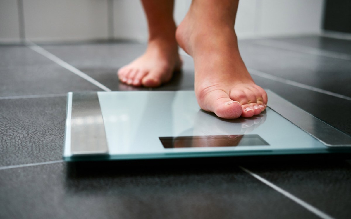 Person getting ready to weigh themselves on a scale.