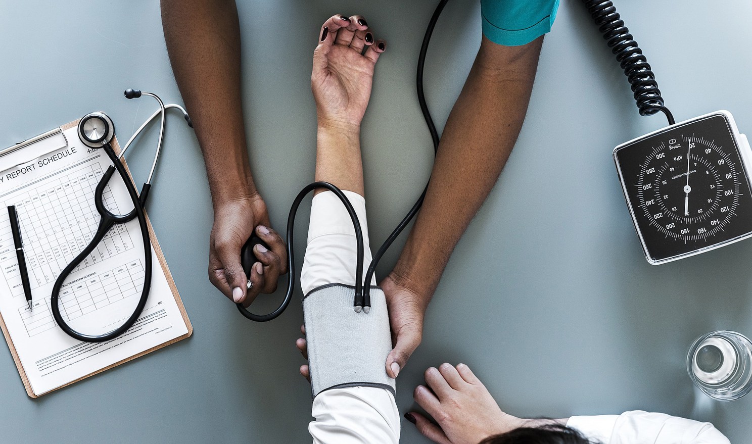 overhead view of a doctor taking a person's blood pressure