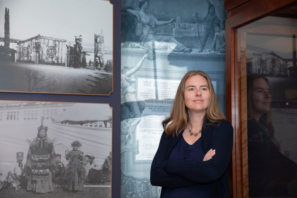 Christina Warinner is a new faculty member photographed in front of a display at the Peabody Museum.