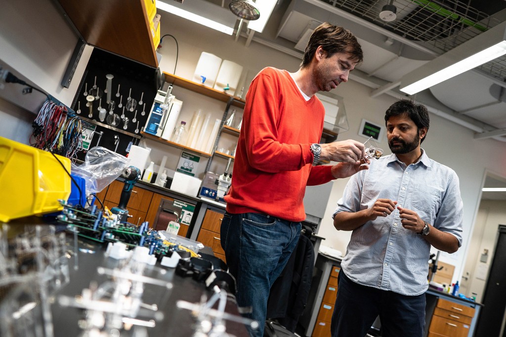 Two researchers talking in a lab.