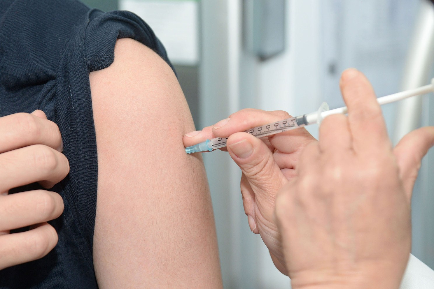 Doctor administering a flue vaccine.