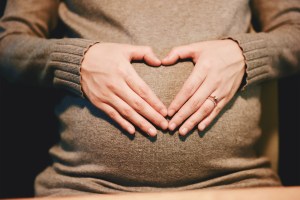 Pregnant woman holding stomach.