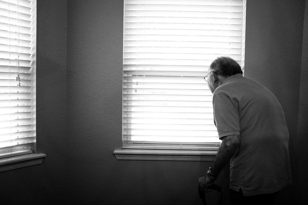 Older man looking out of window.