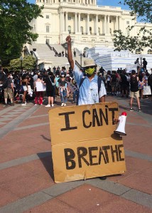 Glenn Foster holds up a sign saying "I can't breathe" in front of the Capitol.