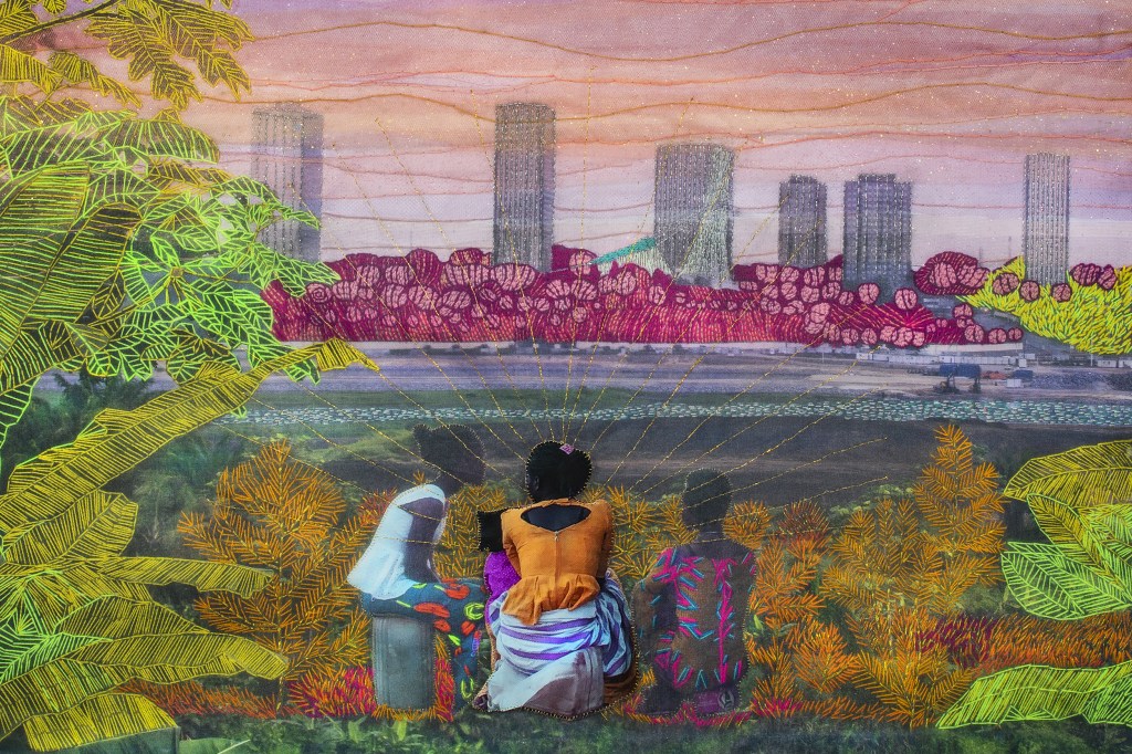 Embroidered photo of three people looking at cityscape and sunset across body of water.