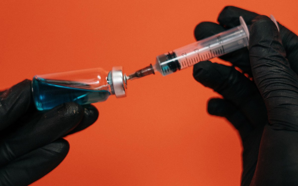 Vaccine being held in gloved hands.