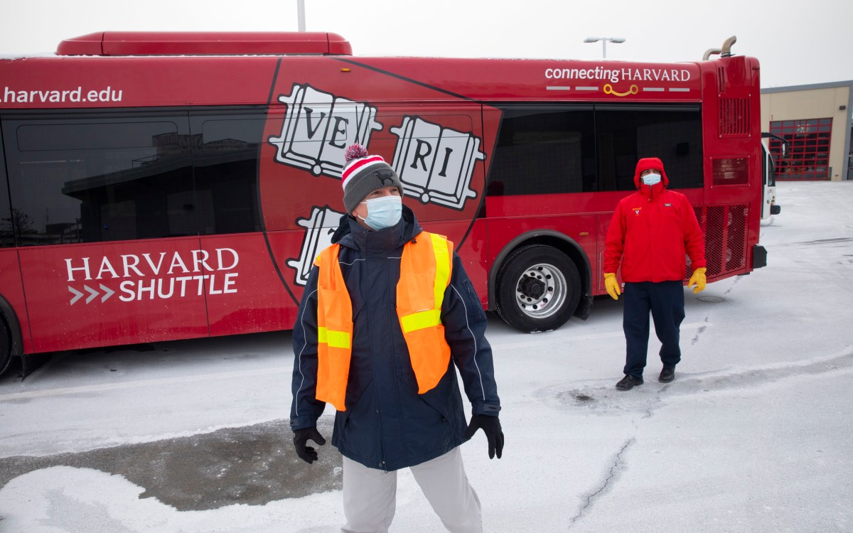 Two Harvard transportation people with bus.