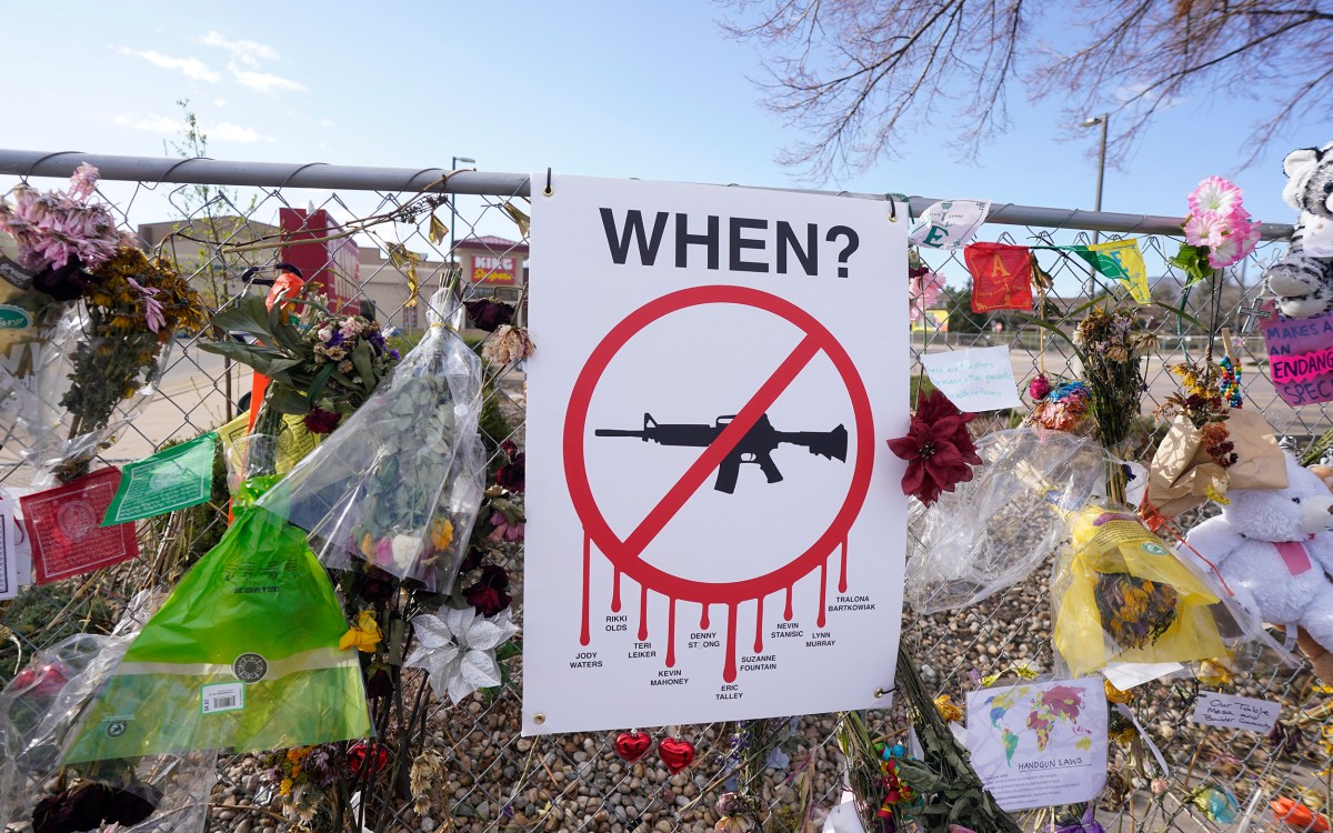 Tributes hang on the temporary fence surrounding the parking lot in front of a King Soopers grocery store.