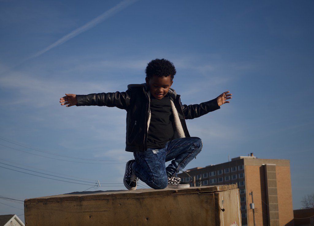 Child posing on a roof.