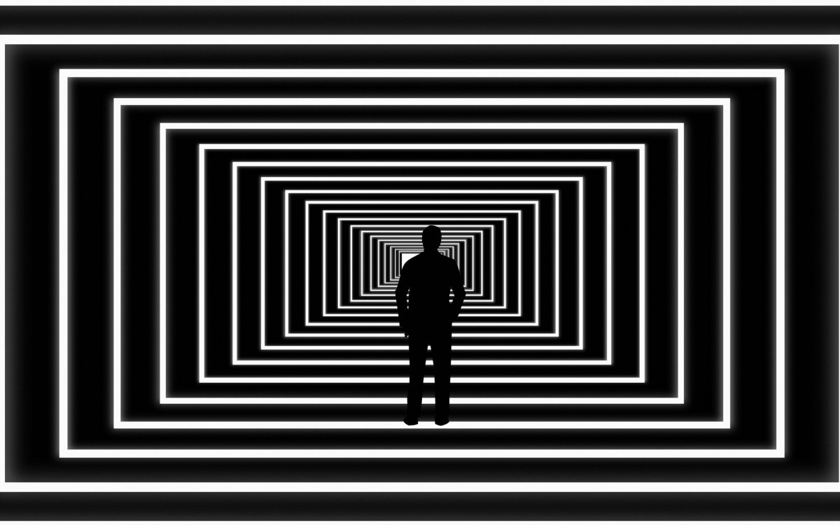 Illustration of person looking at light at end of abstract tunnel.