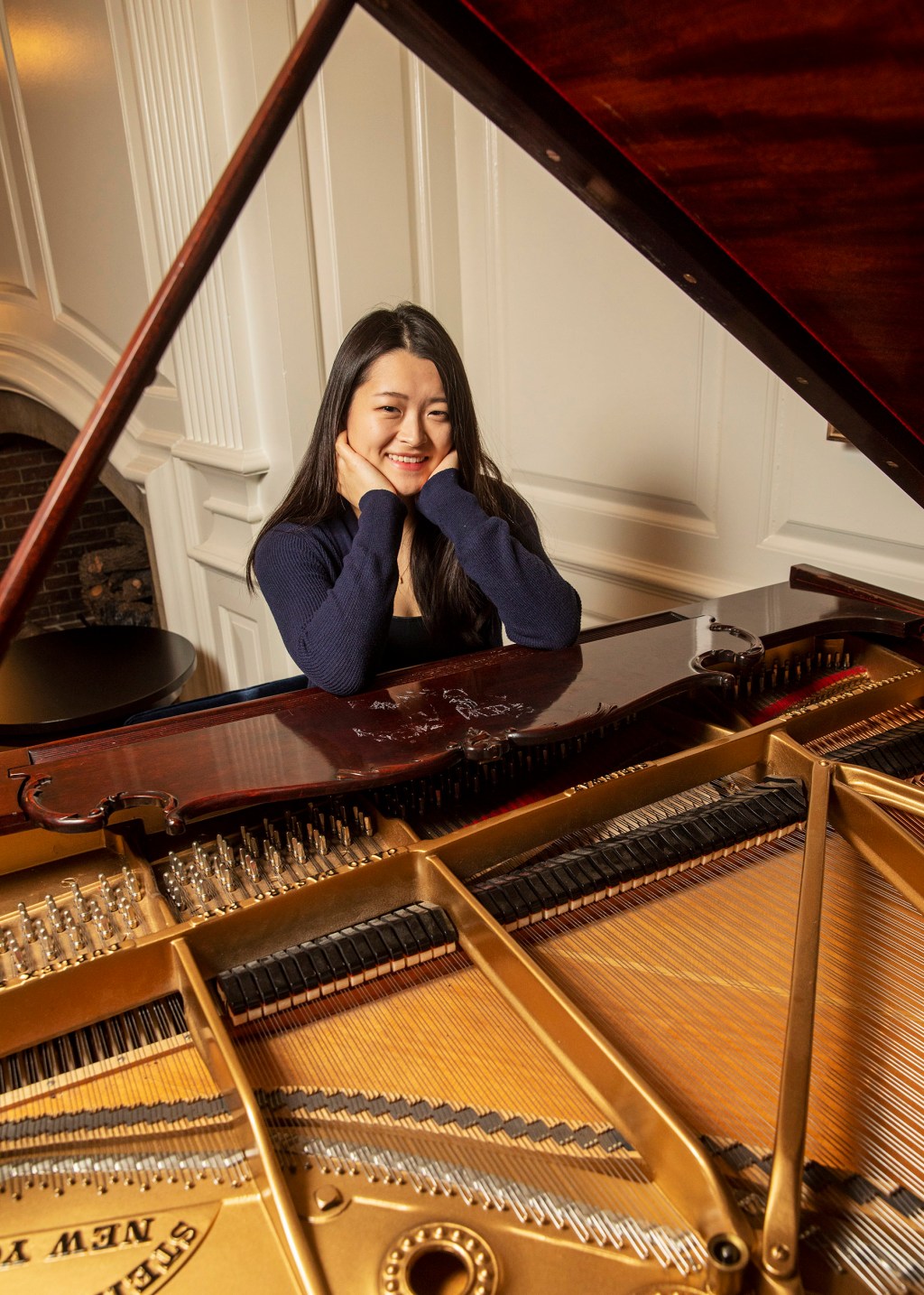 Julia Riew sits at piano.