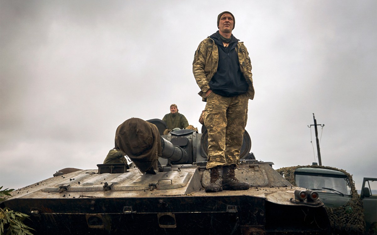 A Ukrainian soldier stands on a tank