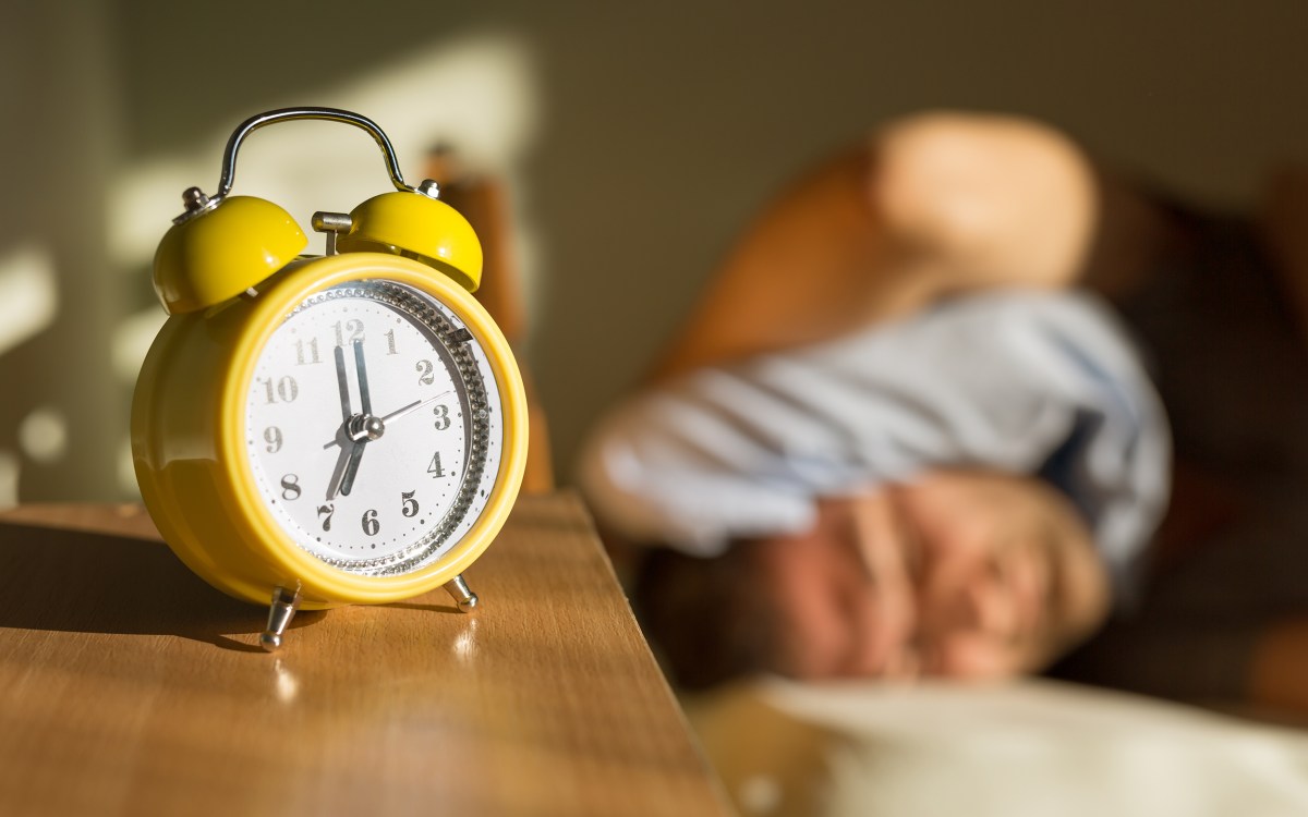research paper on insomnia Person sleeping disturbed by alarm clock.