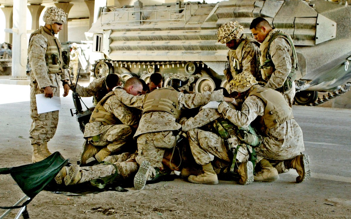 U.S. Marines pray over a fallen comrade.