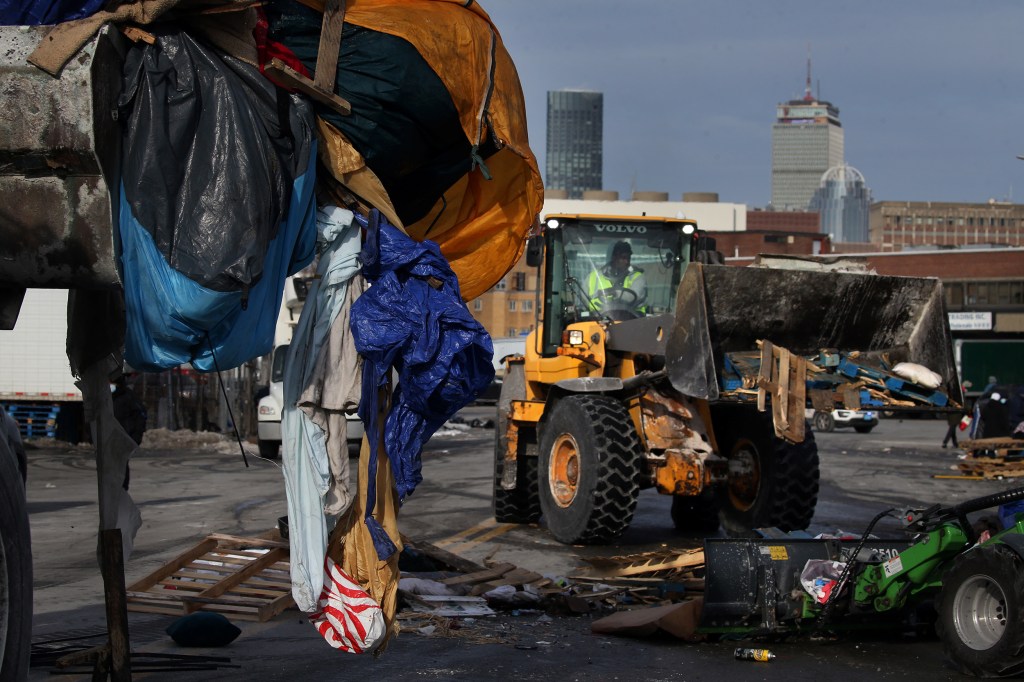 Front-end loaders take down tents and debris.