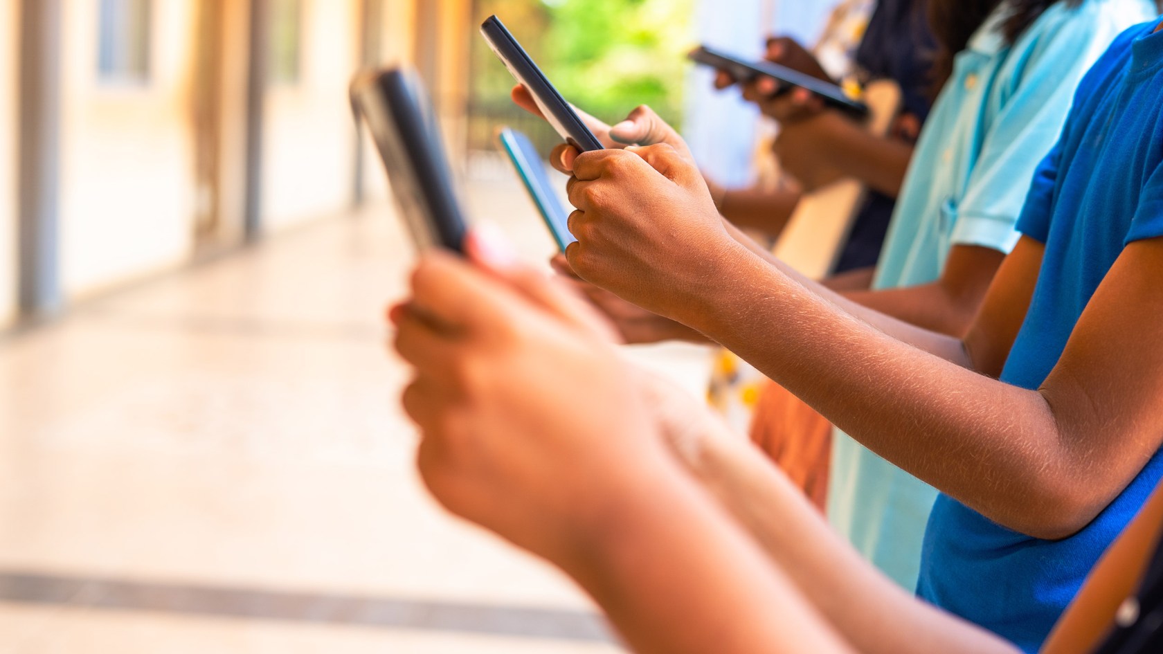 A row of kids on smart phones.