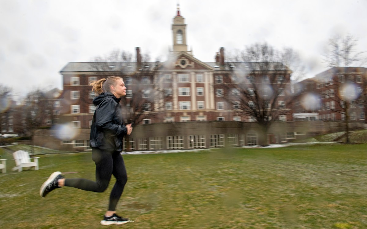 Morgan Sokol runs by Currier House in the rain.