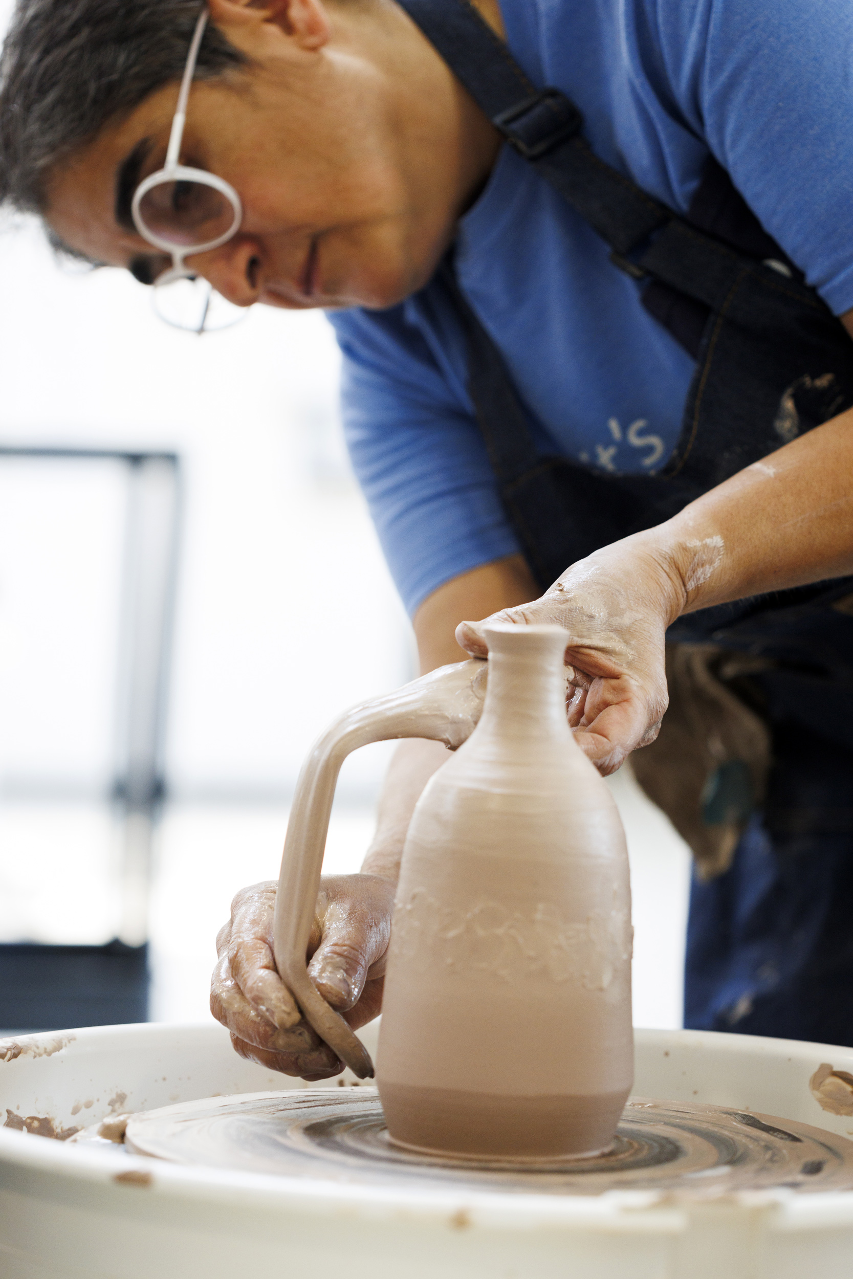 Osorio attaches a handle to a bottle form.