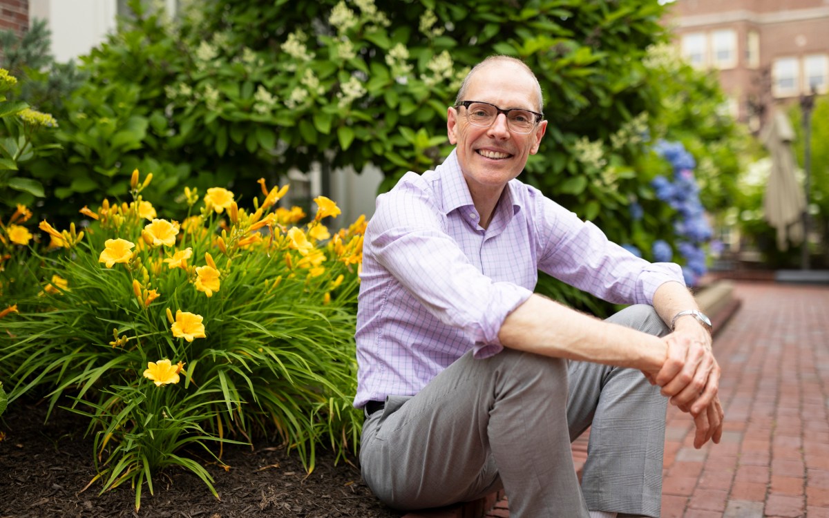 Martin Puchner sitting next to a flower bed.