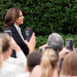 Kamala Harris walks by crowd gathered on White House lawn before speaking at an event.