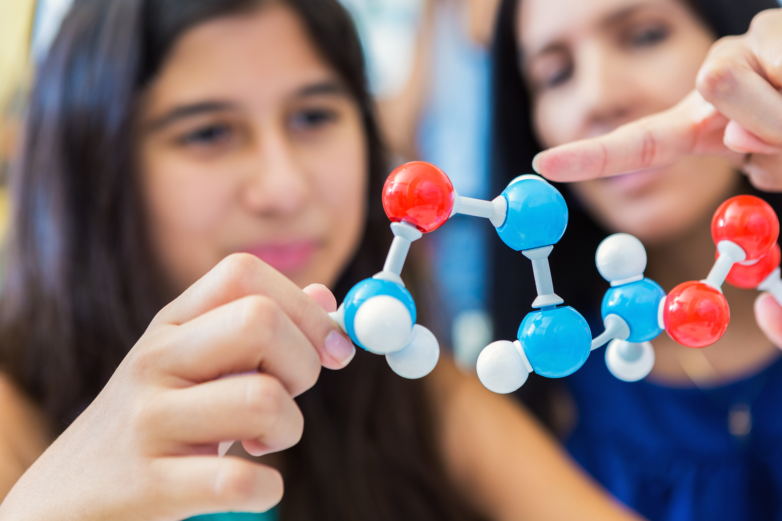 Mother teaching daughter about molecules.