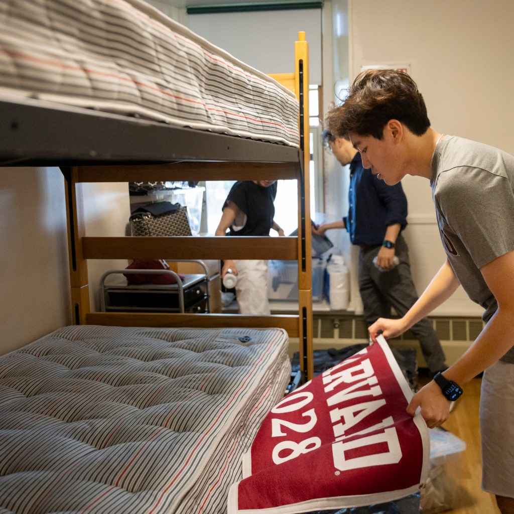 Soo Park (from left), Seung Yoo, and Nicholas Yoo ’28 moving into a room in Holworthy Hall.