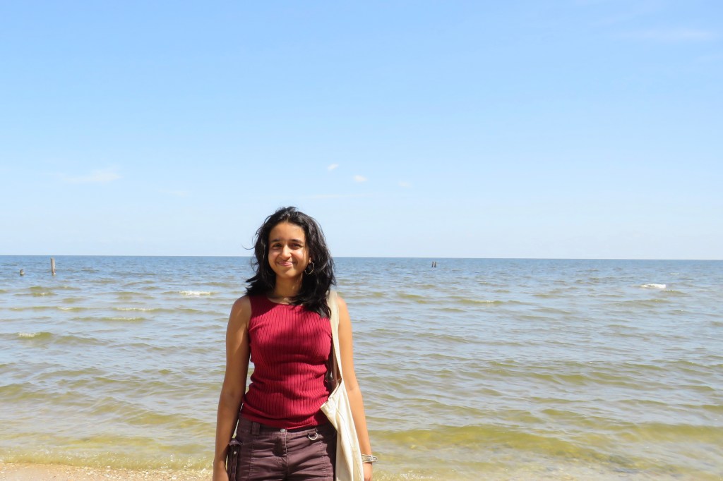 Shruti Gautam standing in front of the ocean.