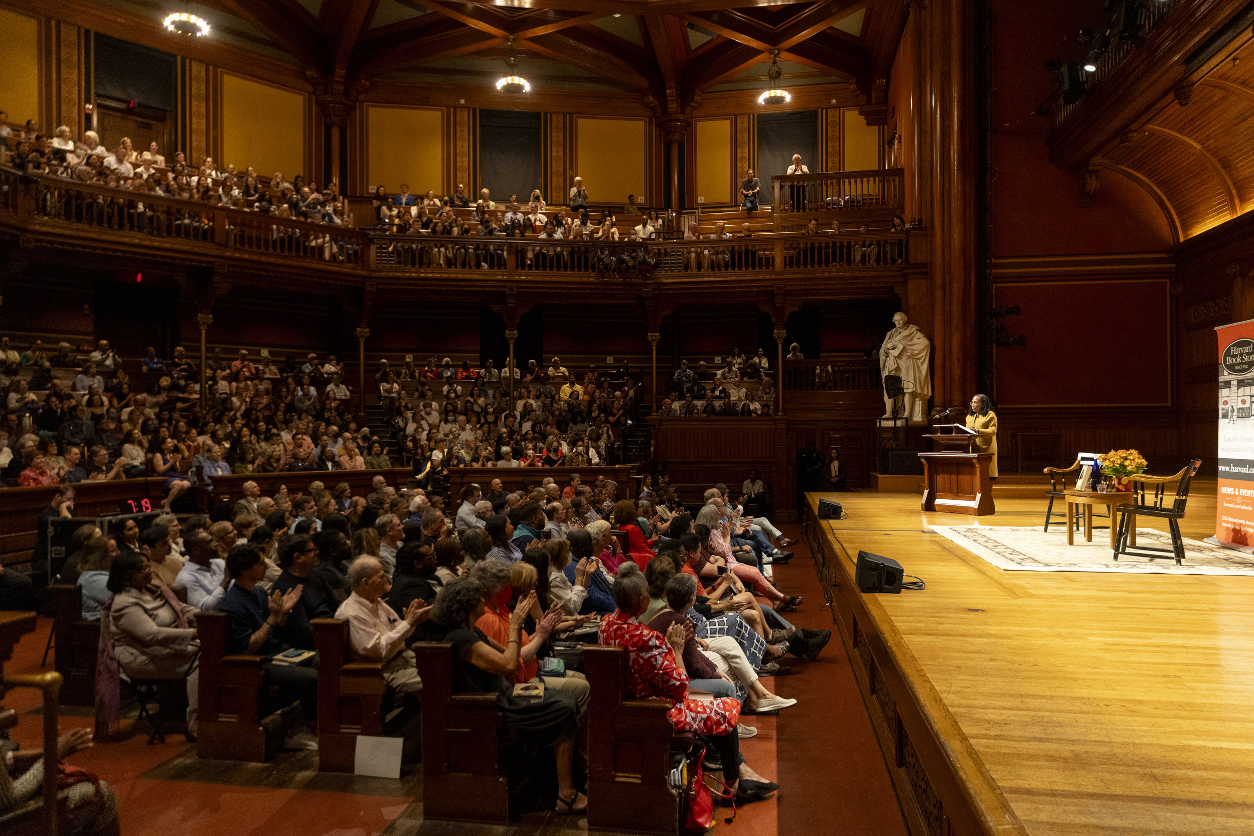 Wide view of crowded Sanders Theatre as Ketanji Brown Jackson speaks the from stage.