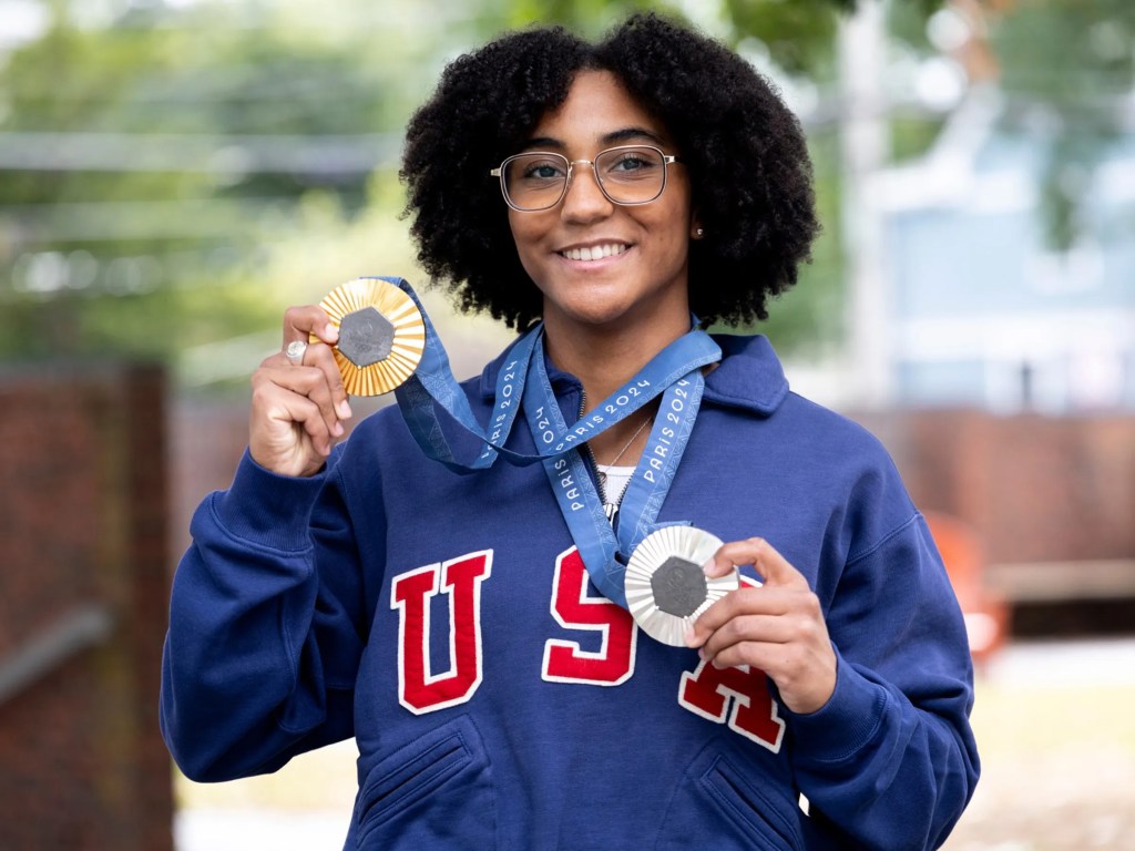 Lauren Scruggs Portrait holding up a silver and gold medal.