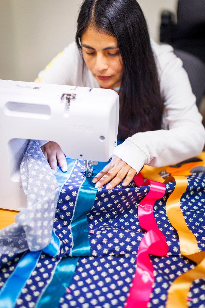 HES graduate student Catherine Dondero (pictured) constructs a ribbon skirt. 