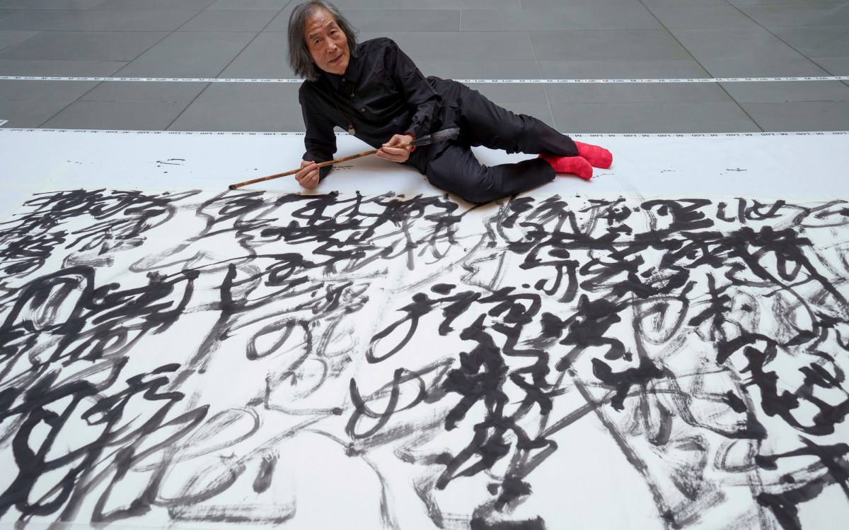 Dongling sitting with his finished calligraphy piece.