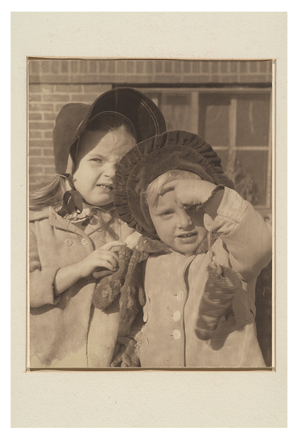 Two young girls embrace as they pose for a photo. 