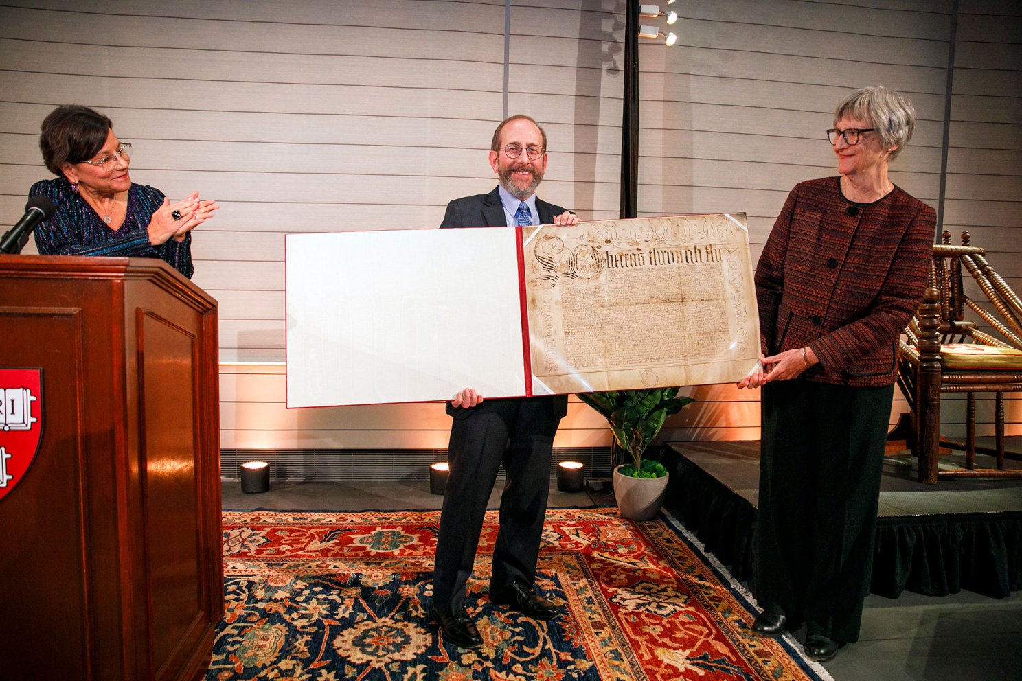 Harvard Corporation Senior Fellow Penny Pritzker (from left), Alan Garber, and President Emerita Drew Faust are pictured as he holds the ceremonial copy of the Harvard Charter.