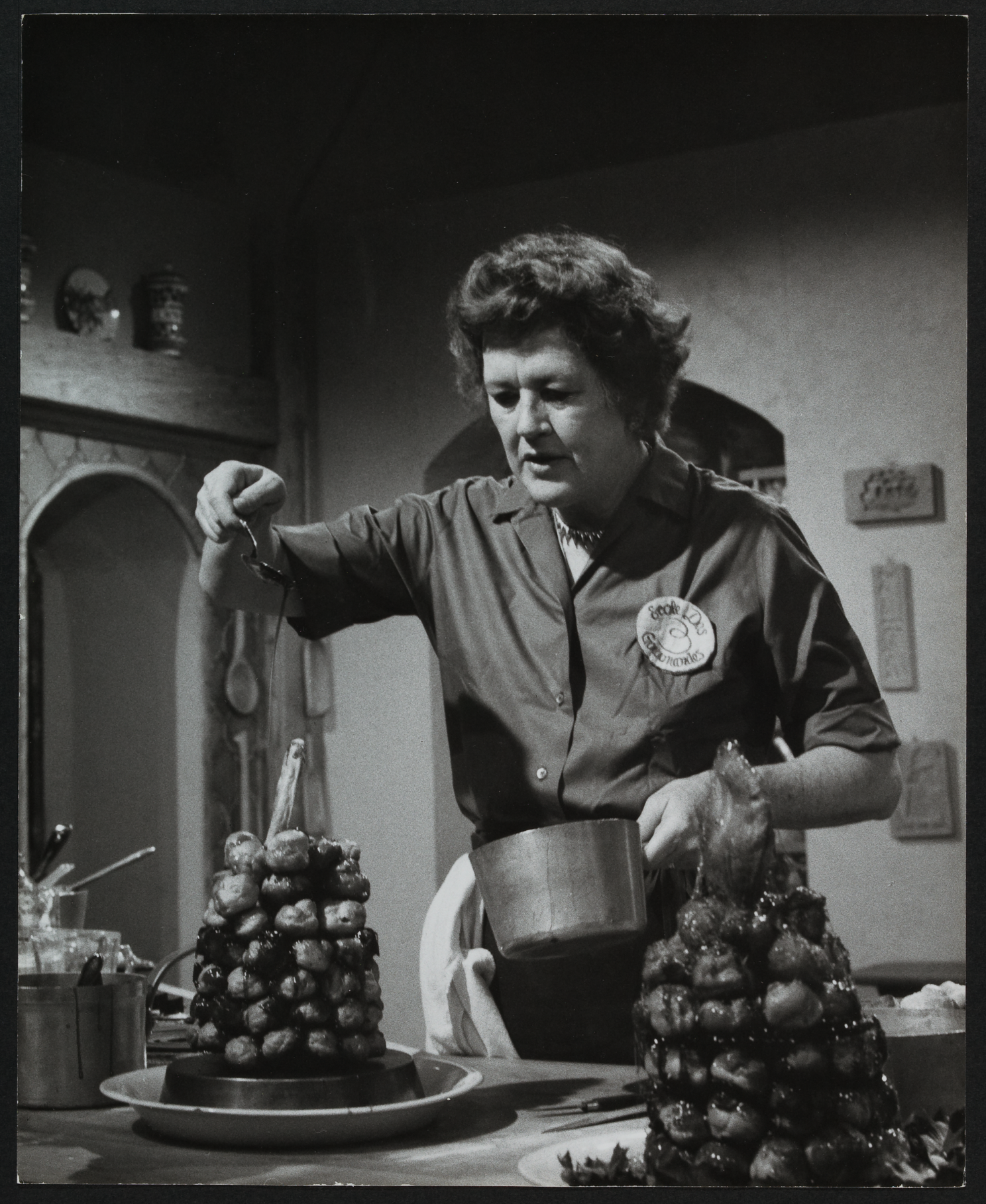 Julia Child in the kitchen using a drizzling technique.