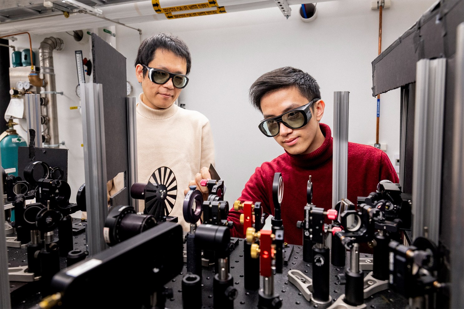 Jian-Xiang Qiu (left) and Professor Suyang Xu adjust the lasers inside the Axion Quasiparticle