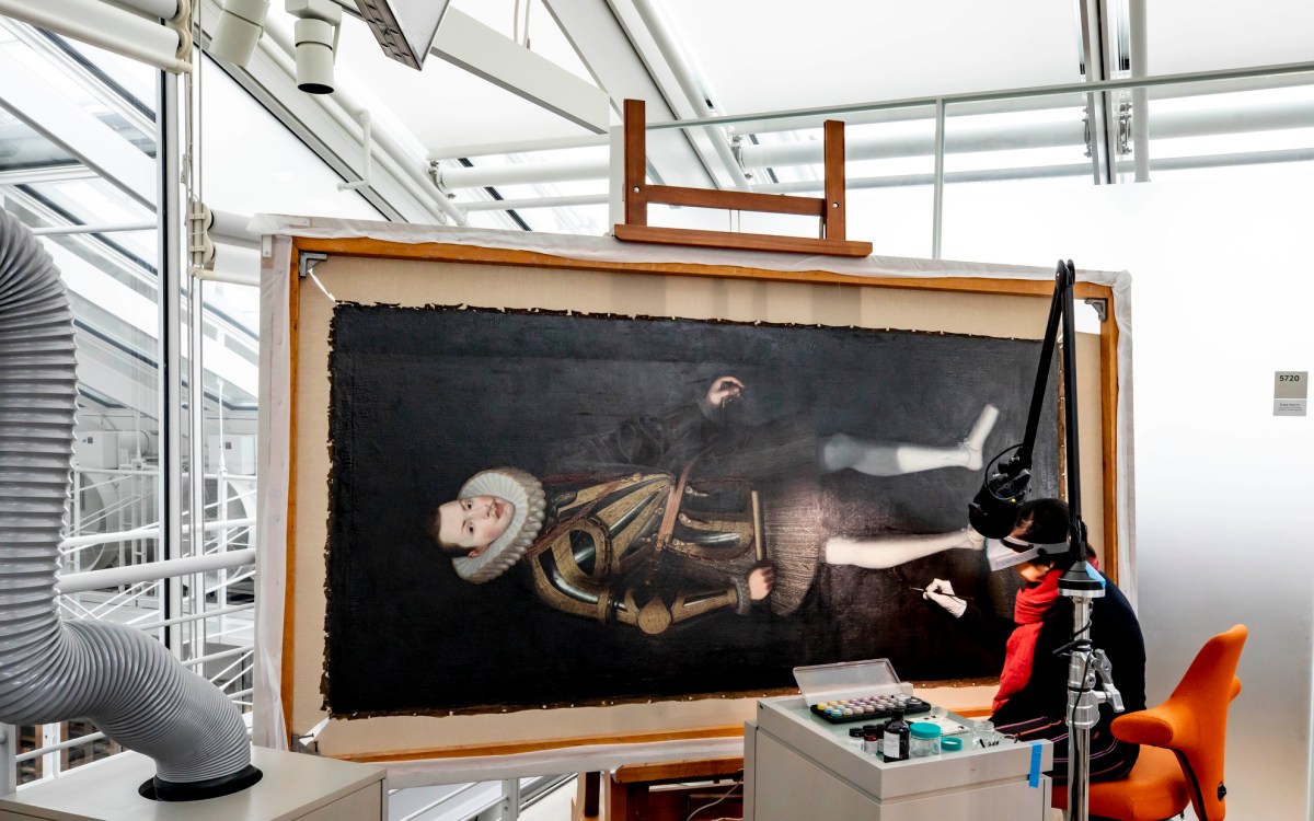 Cristina Morilla, Associate Paintings Conservator conserves a portrait of King Philip of Spain at Harvard Art Museum.