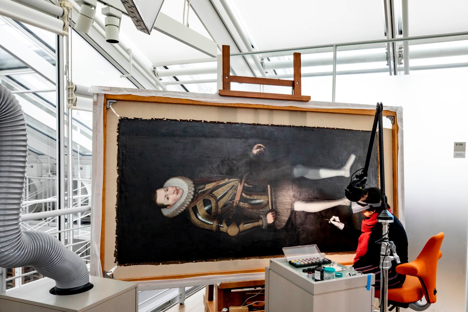 Cristina Morilla, Associate Paintings Conservator conserves a portrait of King Philip of Spain at Harvard Art Museum.