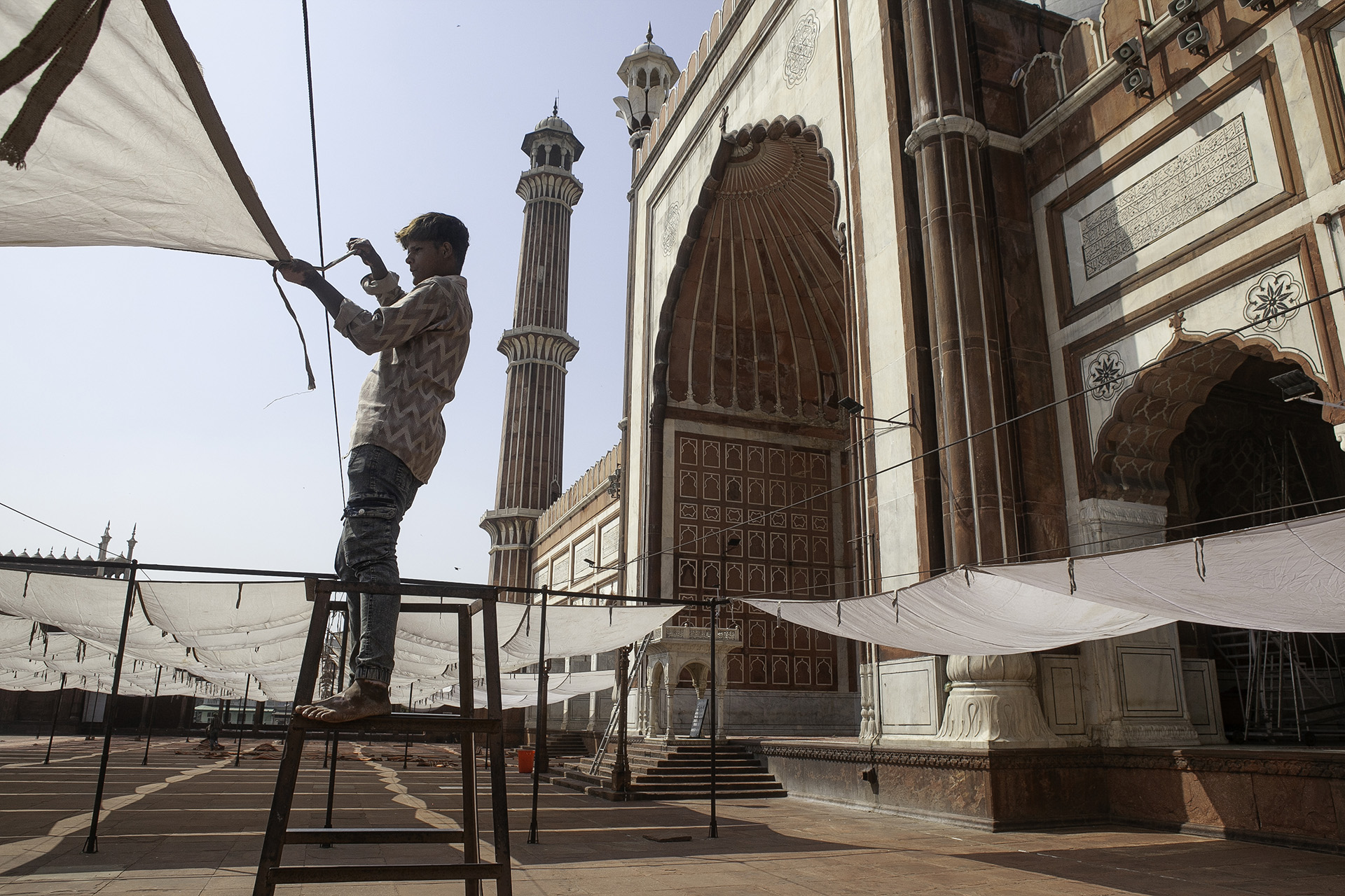 A man puts up canopies at a mosque in Delhi.