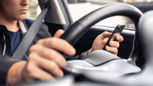 person looking at their phone while driving