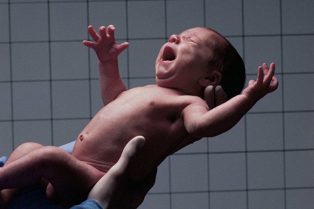 Doctor holding newborn.