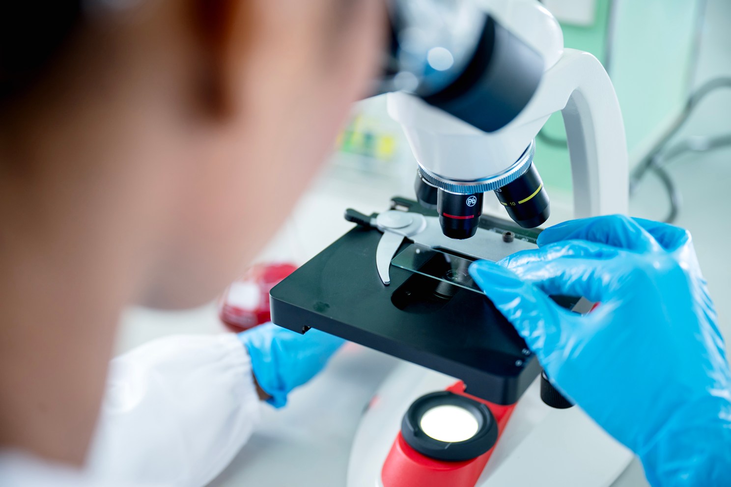 A scientist uses a microscope in a lab.