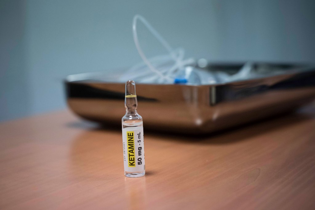 Ketamine in foreground with an IV tube in background.