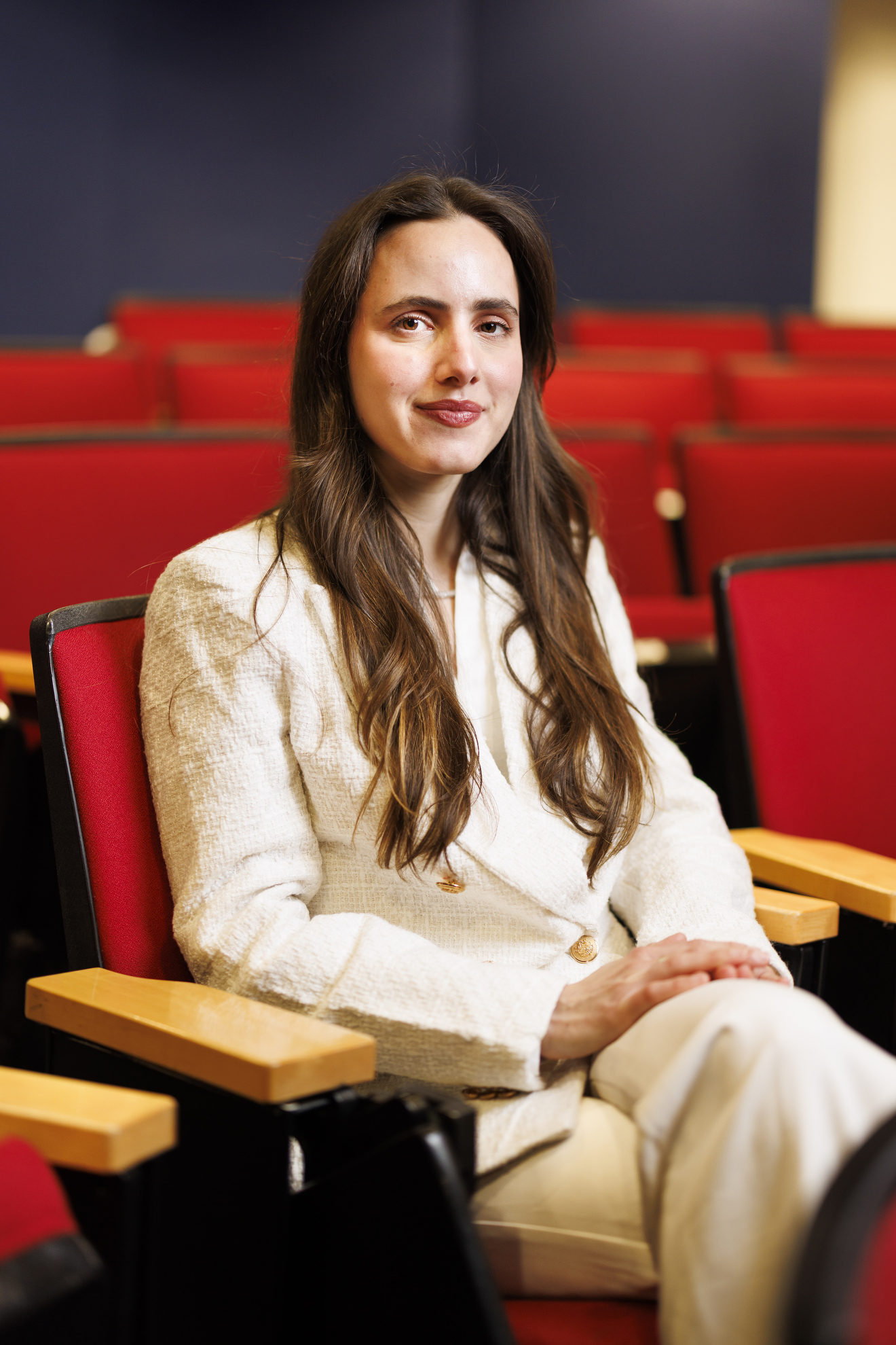 Luiza Lima Vieira sitting in a red theater seat.