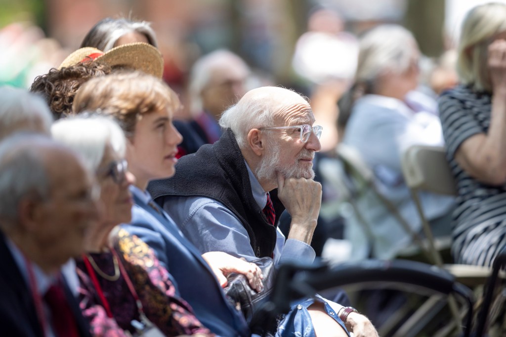 A man listens as Harvard Alumni Day Speaker Courtney B. Vance AB '82 delivers remarks during Alumni Day, 2024.