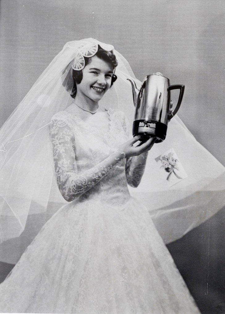 A black and white photograph of a bride holding a coffee percolator